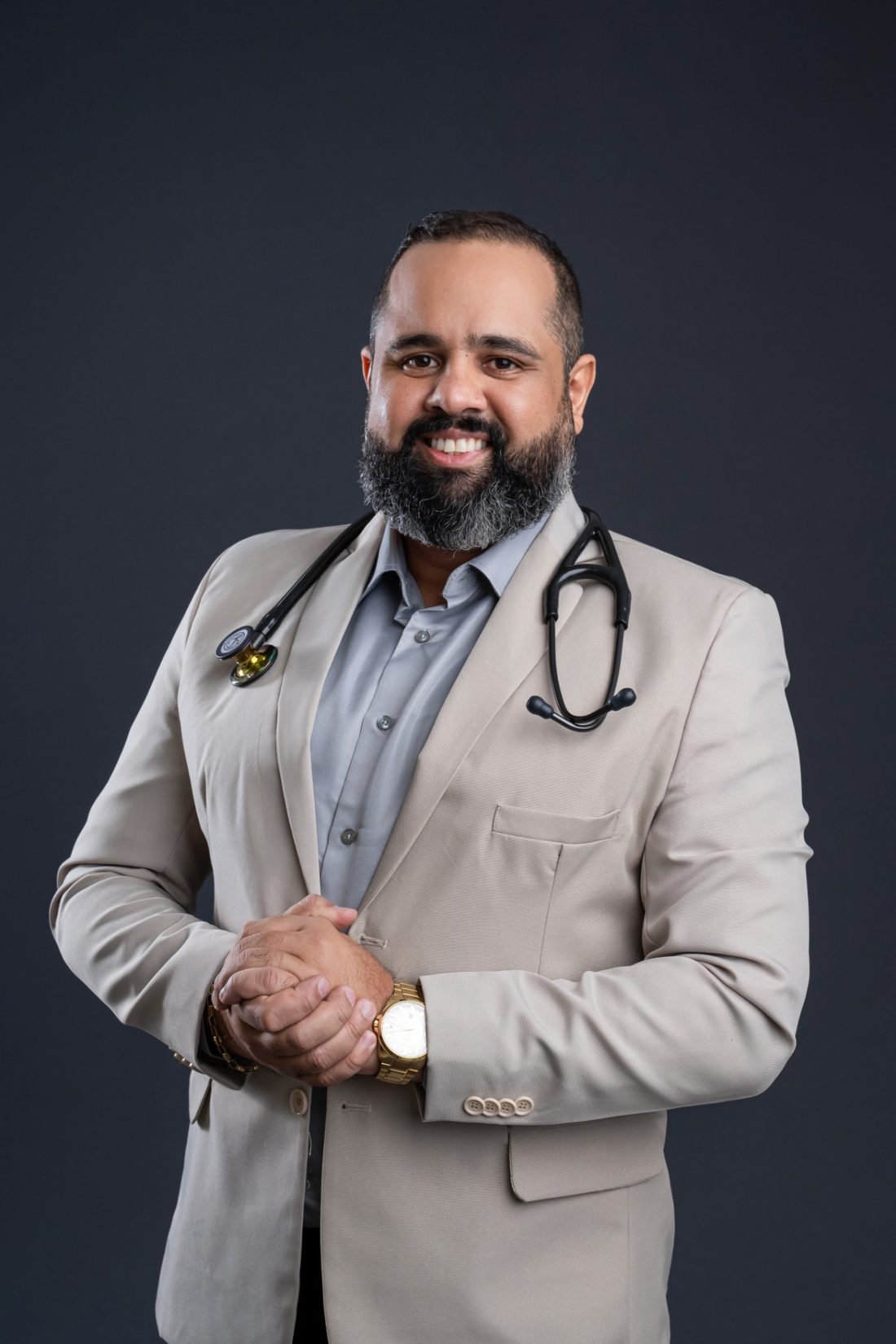 Dr. Julivaldo Silva sorrindo, de blazer claro e estetoscópio